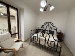 BombaにあるLa Chiave di Volta , Dimora del 500 a 5 minuti dal lagoのベッドと椅子と窓のある寝室