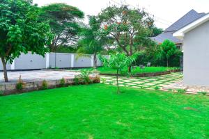 a yard with a green lawn with a tree at Luxury Peace House in Arusha