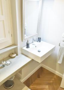 La salle de bains est pourvue d'un lavabo blanc et d'une fenêtre. dans l'établissement Alma Ortigiapart, à Syracuse