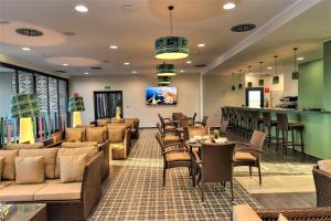 ein Restaurant mit Sofas und Tischen und einer Bar in der Unterkunft Hotel Falcon Thalassa Resort & SPA in Aïn El Turk