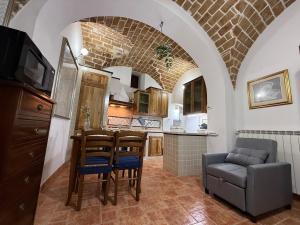 BombaにあるLa Chiave di Volta , Dimora del 500 a 5 minuti dal lagoのキッチン(テーブル、椅子、ソファ付)