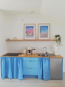 a kitchen with a blue counter with a sink at La mansarde in Nozay