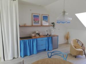 a kitchen with blue cabinets and a sink at La mansarde in Nozay