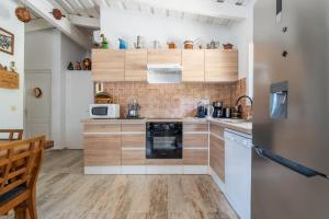 cocina con armarios de madera y lavavajillas negro en La bergerie 1, en Bonifacio