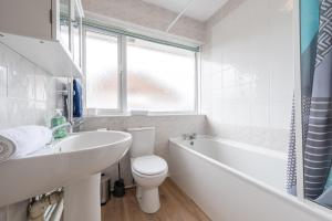 une salle de bain avec un lavabo, des toilettes et une baignoire dans l'établissement High Tee by Tŷ SA, à Cardiff