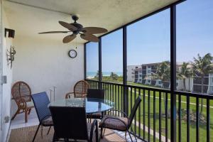 a balcony with a table and chairs and a view of the ocean at Loggerhead 543 - Gorgeous Beachfront Residence at Loggerhead Cay in Sanibel