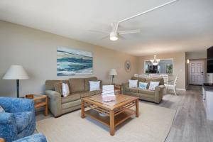 a living room with a couch and a table at Loggerhead 543 - Gorgeous Beachfront Residence at Loggerhead Cay in Sanibel