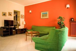 sala de estar con sofá verde y mesa en La Casa Di Rosa en Matera