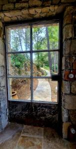 a window in a brick wall with a view of a yard at Le Masdemoiselle Mazet in Salernes