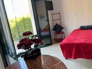Una habitación con una mesa con un jarrón con flores. en Habitacion Oliva, en Olvera