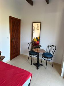 1 dormitorio con mesa, 2 sillas y espejo en Habitacion Oliva, en Olvera