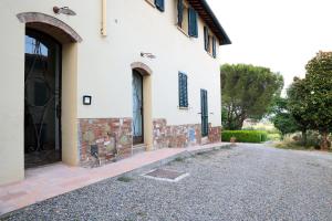 a white house with a black door and a driveway at Tognazzi Casa Vacanze - Appartamento Due Archi in San Gimignano
