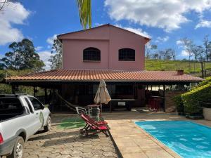a house with a car parked in front of it at Casa de campo Domeni rustica e próximo a cidade de Juiz de Fora MG in Juiz de Fora