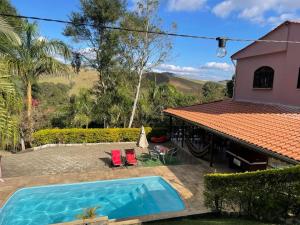 a house with a swimming pool in the yard at Casa de campo Domeni rustica e próximo a cidade de Juiz de Fora MG in Juiz de Fora