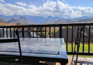 un tavolo e sedie su un balcone con vista sulle montagne di Fairways at Drakensberg Gardens Resort Timeshare a Underberg