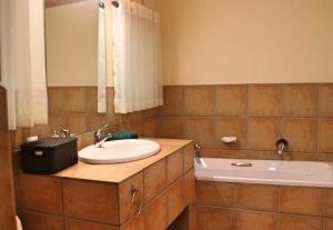 un bagno con lavandino e vasca da bagno di Fairways at Drakensberg Gardens Resort Timeshare a Underberg Altre 4 foto
