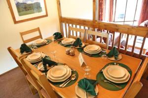un tavolo in legno con tovaglioli e piatti verdi di Fairways at Drakensberg Gardens Resort Timeshare a Underberg