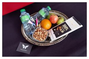 a basket of fruit and nuts and a bottle of water at La MAISON BLANCHE - Ch2C - CENTRAL - CALME - WIFI - White Butterfly Hotels in Dakar