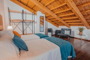 ein Schlafzimmer mit großem Bett und Holzdecke in der Unterkunft Yellow House - Casa 2 in Angra do Heroísmo