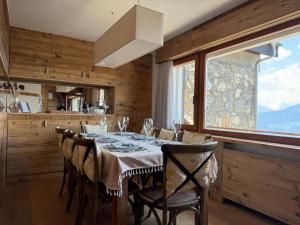 a dining room with a table with chairs and a window at Crans-Montana luxury duplex ,Swiss Alps in Crans-Montana