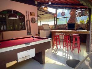 a pool table in a room with a bar and stools at Casa de campo Domeni rustica e próximo a cidade de Juiz de Fora MG in Juiz de Fora +175 photos