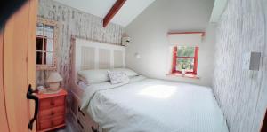 a small bedroom with a bed and a window at Farm accommodation - The Lizard Peninsula, Cornwall in Helston