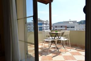 a patio with a table and chairs on a balcony at Penthouse Terrace De Luxe 4 Bedrooms Apartment in Vlorë