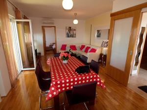 a living room with a table with a red polka dot table cloth at Apartments Jakov in Matulji