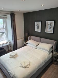 a bedroom with a large bed with two books on it at Heart of Bowness in Bowness-on-Windermere