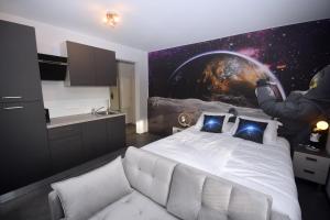 a bedroom with a white bed with a painting on the wall at LUNAR, proche frontière Basel, Free parking in Saint-Louis