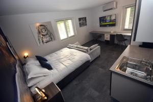 a bedroom with a bed and a sink in it at LUNAR, proche frontière Basel, Free parking in Saint-Louis
