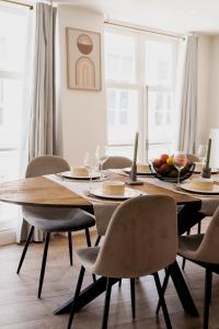 een eetkamer met een houten tafel en stoelen bij The Rembrandt - Residence in Amsterdam +29 foto's