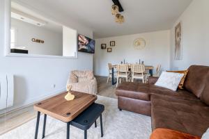 una sala de estar con un sofá y una mesa en Le Mana, 7 pers 2 chambres 12min Disneyland Paris, en Bailly-Romainvilliers