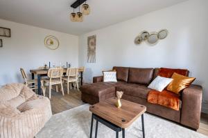 una sala de estar con un sofá y una mesa en Le Mana, 7 pers 2 chambres 12min Disneyland Paris, en Bailly-Romainvilliers