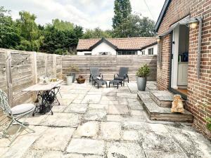 a patio with chairs and a table and a fence at Spike by The Suffolk Cottage Collection in Chillesford