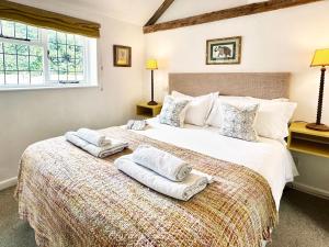 a bedroom with a large bed with towels on it at Spike by The Suffolk Cottage Collection in Chillesford