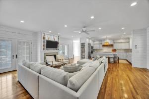 ein großes weißes Wohnzimmer mit einem großen Sofa in der Unterkunft Spacious 7 Bed Retreat with Game Room, Deck, Yard, Half a Block from Ocean, Host Up to 22 Across 16 Beds, Gas Fireplace, Gas Grill, Ample Parking, Walk to Menauhant Beach, 24 Hr Hospitality in Falmouth