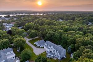 eine Luftaufnahme eines Hauses im Wald in der Unterkunft Spacious 7 Bed Retreat with Game Room, Deck, Yard, Half a Block from Ocean, Host Up to 22 Across 16 Beds, Gas Fireplace, Gas Grill, Ample Parking, Walk to Menauhant Beach, 24 Hr Hospitality in Falmouth