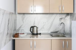 a kitchen with white marble walls and a sink at Hotel Palas Grand View in Iaşi