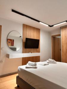 a bedroom with a bed and a mirror and a tv at Quince city center 3 in Heraklio