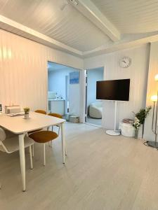 un soggiorno con un tavolo e una tv di Big Star Stay a Busan