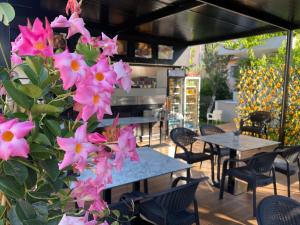 a group of tables and pink flowers on a patio at Zace Studios in Ksamil