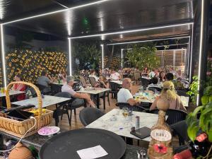 a group of people sitting at tables in a restaurant at Zace Studios in Ksamil