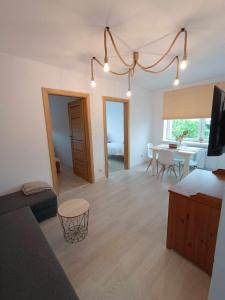 a living room with a couch and a dining room at Apartament Mazury in Ryn +8 photos