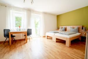 a bedroom with a bed and a desk and a table at Hotel Donau-Ries & Restaurante Delphi in Mertingen