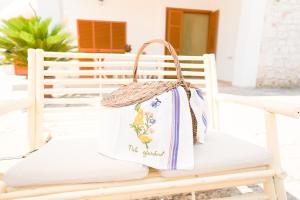 a white bag sitting on a white bench at Dimora Sorelle del Mar - Polignano a Mare in Polignano a Mare