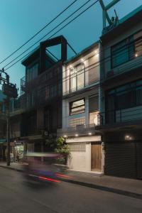un bâtiment situé dans une rue où une voiture passe dans l'établissement LumiLoft, à Bangkok