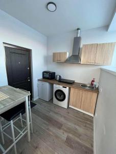 a small kitchen with a table and a stove at 1 kambario apartamentai in Raseiniai +11 photos