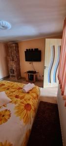 a bedroom with a large bed with a sunflower bedspread at Casa de vacanta La Fane in Valcea