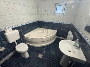 a bathroom with a tub and a toilet and a sink at Casa Alex in Piteşti